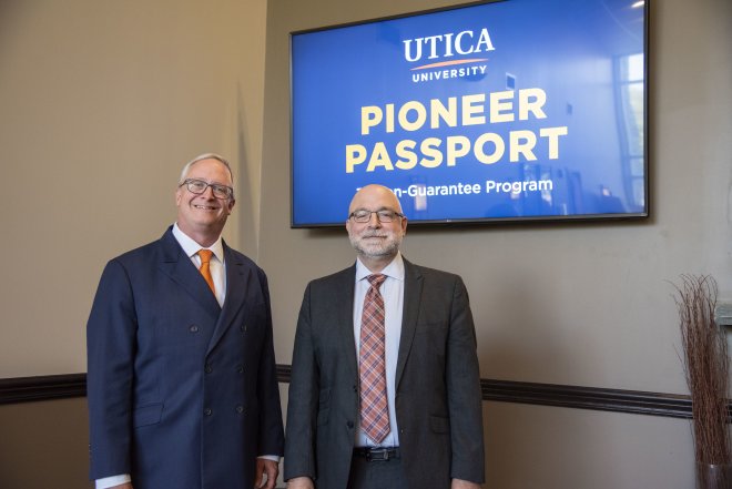 President Todd Pfannestiel and VP of Enrollment Management Eric Sykes stand in front of monitors announcing Pioneer Passport.